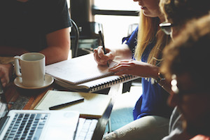 Team of people working together at a coffee table